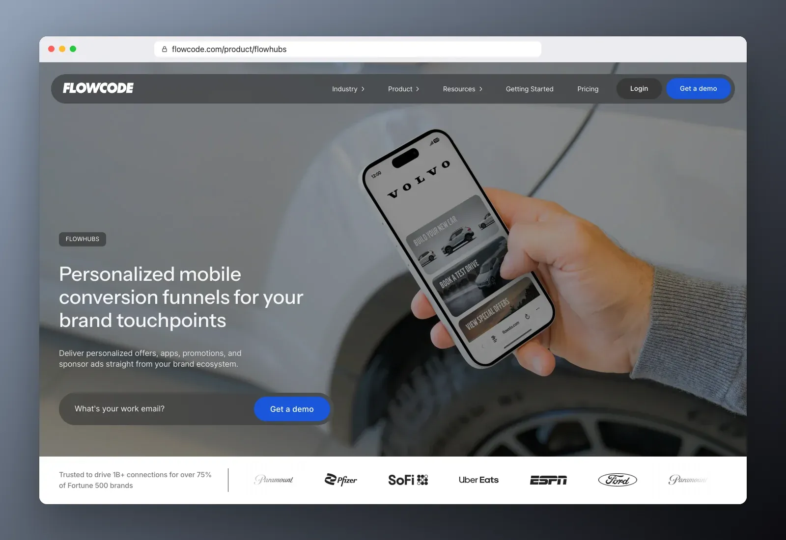 Real screenshot of the Flowcode Flowhubs homepage at flowcode.com in a browser, showing the Flowhubs page, a hand holding a phone with a mobile funnel, and brand logos